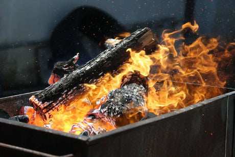 Burning Logs In Bright Orange Flames Inside a Metal Container For Wood-fired Oven Recipes.