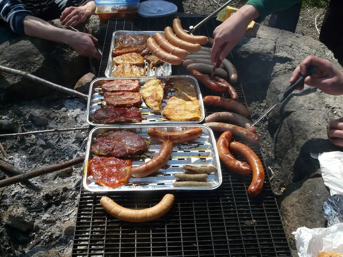 Outdoor Barbecue Grill Sizzling With Assorted Meats On Metal Trays Using Kiln Dried Wood.