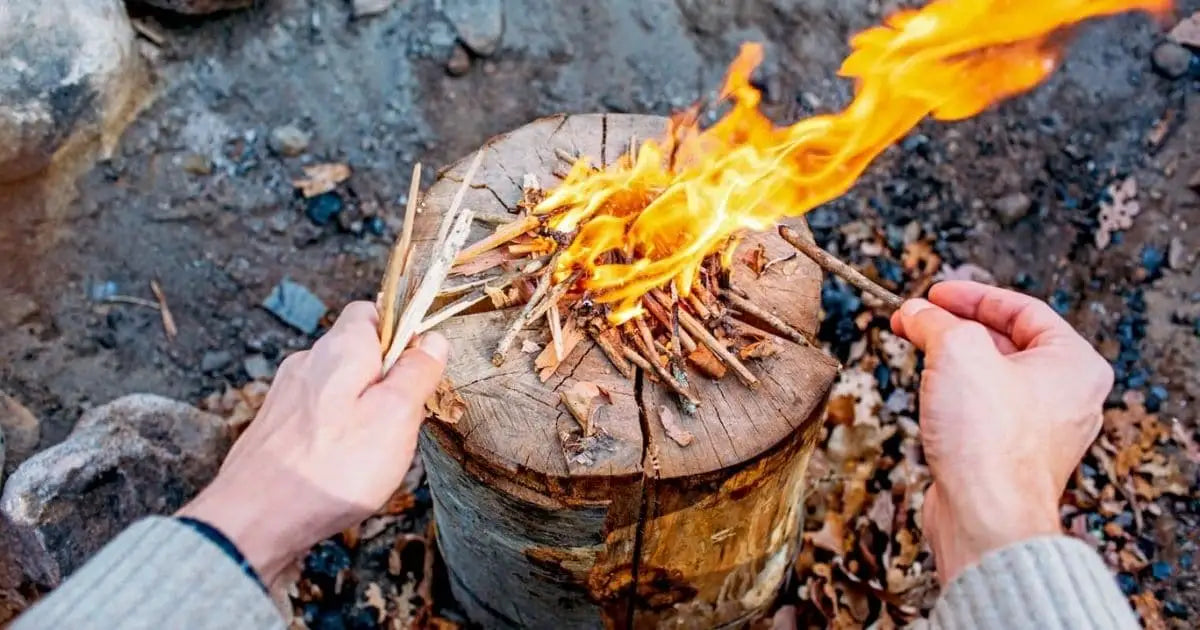 Burning kindling on a wooden log for Swedish Torch cooking outdoors