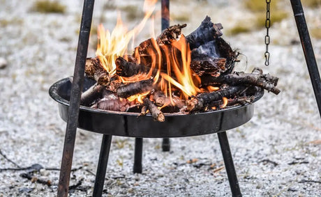 Portable Fire Pit With Burning Logs In a Bbq Comparison Of Kiln Dried Wood Vs. Lumpwood Charcoal.